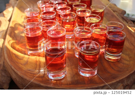 Off-site catering on the street. Mixed alcohol slurt in stacks of glasses stand on a tray 125019452