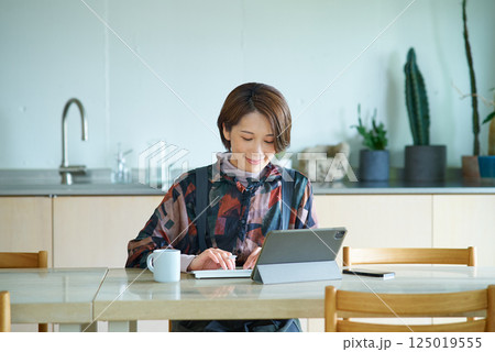 リビングルームで仕事をする女性 125019555