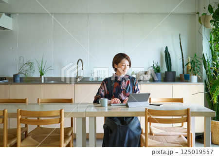 リビングルームで仕事をする女性 リビングルームで仕事をする女性 125019557