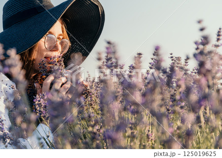 Woman in a Hat Smelling Lavender 125019625