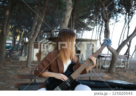 Girl Plays The Bass Instrument In The Countryside In Summer Girl Plays The Bass Instrument In The Countryside In Summer 125020543