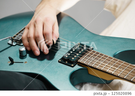 Close up of man playing on electric guitar 125020896