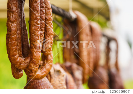 Smoked sausages meat hanging in smokehouse 125020907