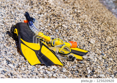 Flippers and snorkeling tube on sea shore Flippers and snorkeling tube on sea shore 125020920