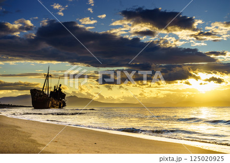 Rusty broken shipwreck on sea shore Rusty broken shipwreck on sea shore 125020925
