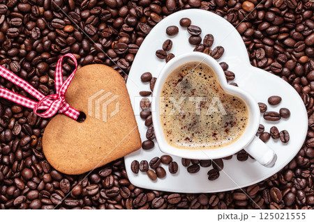 Heart shaped cup and cookie on coffee beans background 125021555