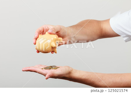 Male hands with coins and piggybank 125021574