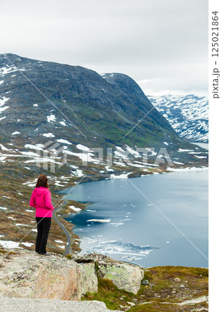 Tourist woman standing by Djupvatnet lake, Norway Tourist woman standing by Djupvatnet lake, Norway 125021864
