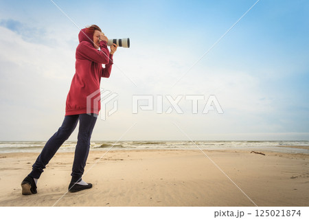 Woman taking pictures on coastline 125021874