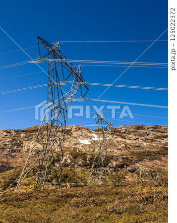 Power line voltage tower in mountains against blue sky Power line voltage tower in mountains against blue sky 125022372