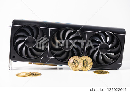 Modern black graphics card with three cooling fans and golden Bitcoin coins on white background, symbolizing GPU cryptocurrency mining hardware 125022641