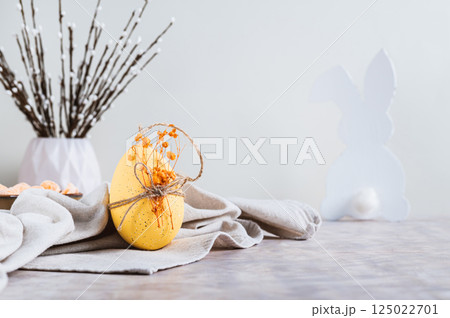 Easter decorated egg on fabric, bunny and pussy willow on table 125022701
