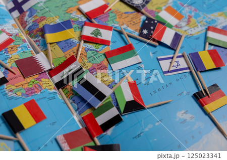 Flags of different countries are scattered on the map. Close-up of the flags. Flags of Ukraine, Lebanon, Israel, Germany, Iran and other countries 125023341