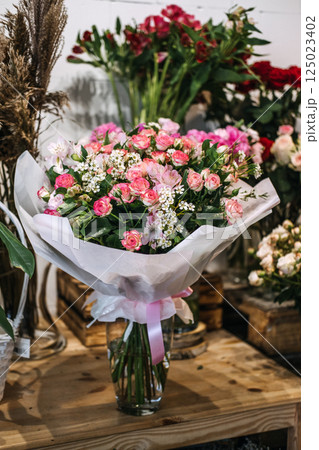 Bouquet of pink and white flowers wrapped in tissue and ribbon displayed in a florist shop. Floral business marketing, romantic gifting, small business retail, botanical styling Bouquet of pink and white flowers wrapped in tissue and ribbon displayed in a florist shop. Floral business marketing, romantic gifting, small business retail, botanical styling 125023402