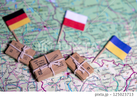 The flags of Germany, Poland and Ukraine lie on a world map next to delivered parcels. Economy, aid, trade The flags of Germany, Poland and Ukraine lie on a world map next to delivered parcels. Economy, aid, trade 125023713