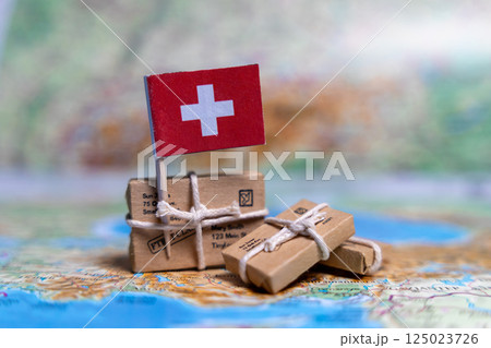 Flag of Switzerland near the parcels on the world map. World trade. Exports and imports of goods. Economy of the country 125023726