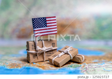 Flag of USA near the parcels on the world map. World trade. Exports and imports of goods. Economy of the country. 125023727