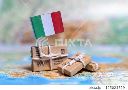 Flag of Italy near the parcels on the world map. World trade. Exports and imports of goods. Economy of the country. Flag of Italy near the parcels on the world map. World trade. Exports and imports of goods. Economy of the country. 125023729