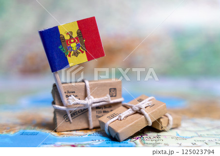 Flag of Moldova near the parcels on the world map. World trade. Exports and imports of goods. Economy of the country 125023794