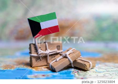 Flag of Kuwait near the parcels on the world map. World trade. Exports and imports of goods. Economy of the country. Flag of Kuwait near the parcels on the world map. World trade. Exports and imports of goods. Economy of the country. 125023804