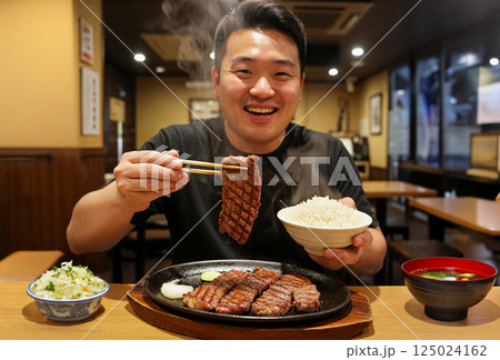 焼き肉定食を食べる男性 125024162