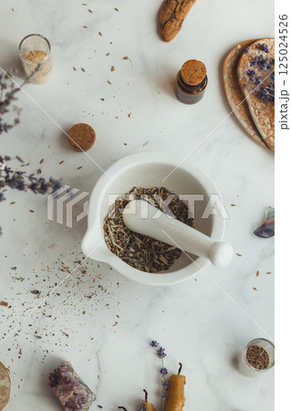 Top view of different wild herbal medicinal plants gathered on a white marble table. Dried herbs tea in mortar and pestle and lavender aside. Herbalist, aromatherapy concept 125024526