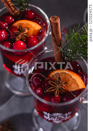 Two glasses of hot red mulled wine decorated with orange, cinnamon and anise. Dark background, cozy atmosphere, festive mood. Family time, new year eve 125024573