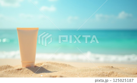 Sunscreen tube on sand against blurred ocean waves. Beach skincare mockup with copy space. Summer vacation and sun protection concept 125025187