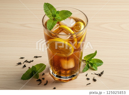 Refreshing iced tea with lemon and mint in a glass on wooden table 125025853