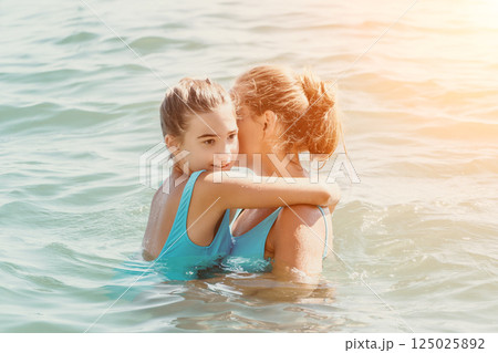 Mother and Daughter Embrace in the Ocean 125025892