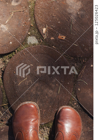 Brown leather barefoot shoes standing on wooden eco path in spring or autumn, sunny weather, top view Brown leather barefoot shoes standing on wooden eco path in spring or autumn, sunny weather, top view 125026423