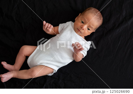 Newborn Baby on Black Background Newborn Baby on Black Background 125026690