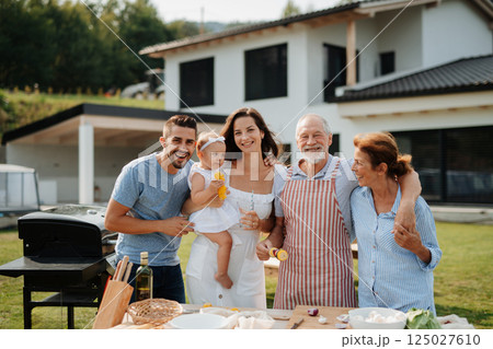 Three generations of family preparing food for a spring weekend barbecue. Three generations of family preparing food for a spring weekend barbecue. 125027610