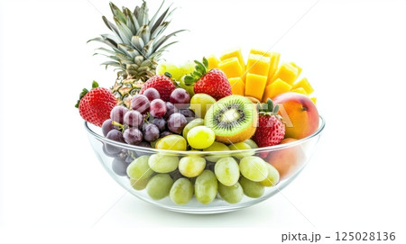 Glass bowl filled with assorted fresh fruits including kiwi, strawberries, grapes, pineapple and mango, vibrant colors and glossy textures, isolated on white background, concept of healthy food 125028136