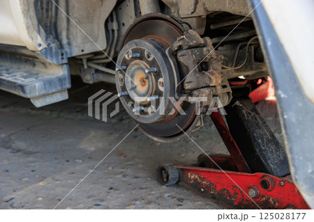 Mechanic changing a wheel of a modern car Mechanic changing a wheel of a modern car 125028177