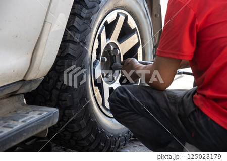 Mechanic changing a wheel of a modern car 125028179