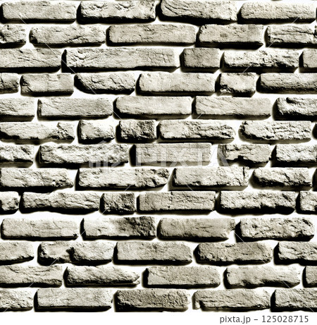 Gray brick wall forming a textured background with light and shadow 125028715