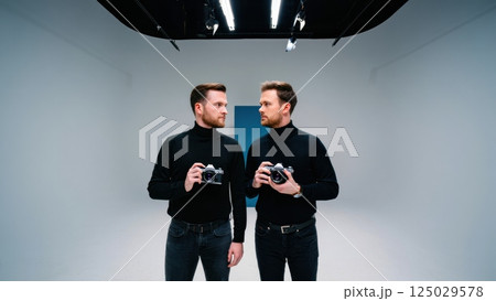 Two identical people fave to face, doppelganger concept, twin, double Two identical people fave to face, doppelganger concept, twin, double 125029578