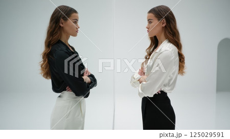 Two identical people fave to face, doppelganger concept, twin, double Two identical people fave to face, doppelganger concept, twin, double 125029591