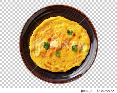 Delicious golden-yellow omelette garnished with fresh herbs, served on a dark brown plate. Perfect for breakfast, brunch, or menu imagery. Delicious golden-yellow omelette garnished with fresh herbs, served on a dark brown plate. Perfect for breakfast, brunch, or menu imagery. 125029972