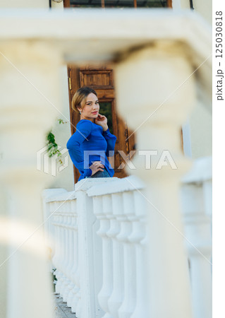 Portrait of a beautiful woman in a blue dress walking fashionably around the city 125030818