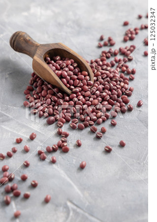 Scoop full of dried azuki beans on gray closeup. East Asian legumes, vegetarian protein source 125032347