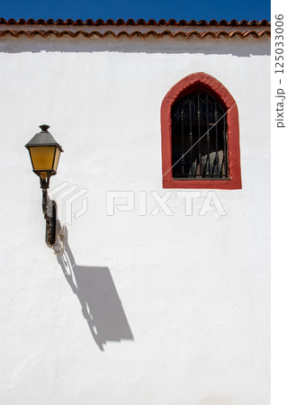 Lantern with its shadow on a white wall, Spain 125033006