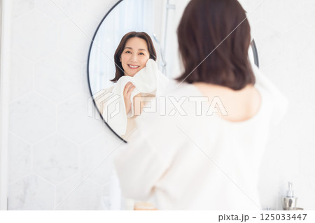 タオルを頬に当てる女性 125033447