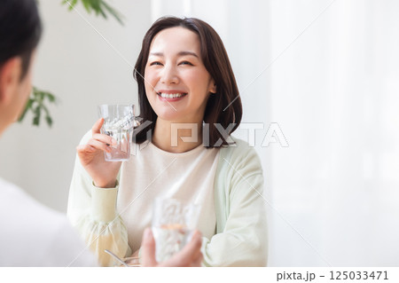 水の入ったグラスを持つカップル 125033471
