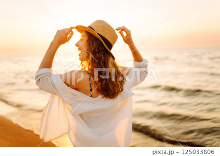 Happy woman on beach in summer style fashion trend outfit carefree and happy, feeling freedom. Happy woman on beach in summer style fashion trend outfit carefree and happy, feeling freedom. 125033806
