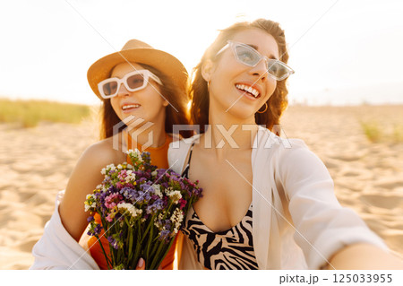 Two pretty friends women making selfie on beach, light and bright summer colors. Friends together Two pretty friends women making selfie on beach, light and bright summer colors. Friends together 125033955