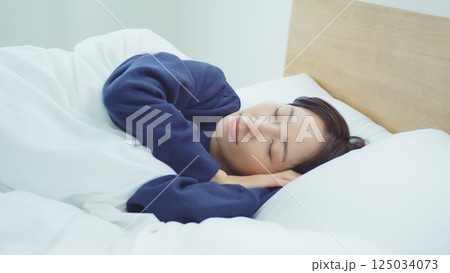 ベッドで寝ている女性 125034073