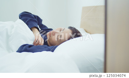 ベッドで寝ている女性 125034074