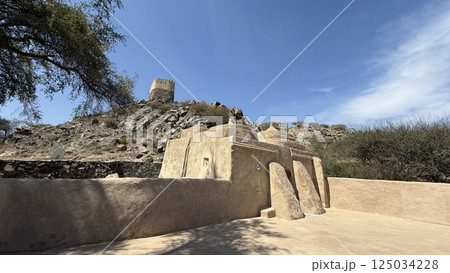 Fujairah, UAE - March 08, 2025: Al Bithnah Fort , Al Bidya Mosque.Geometric patterns painted on mud-brick homes of Asir, sunlight accentuating vibrant traditional colors, historic village streets Fujairah, UAE - March 08, 2025: Al Bithnah Fort , Al Bidya Mosque.Geometric patterns painted on mud-brick homes of Asir, sunlight accentuating vibrant traditional colors, historic village streets 125034228